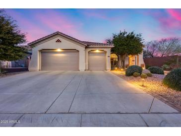 Charming single-story home showcasing a spacious driveway and a low maintenance desert landscape at 42001 N Bridlewood Way, Phoenix, AZ 85086