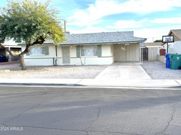 Charming single story home with a well-maintained front yard, long driveway, and a mature shade tree at 1757 W Argon St, Mesa, AZ 85201