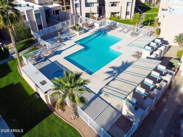Aerial view of a community pool featuring lounge seating, desert landscaping, and a jacuzzi at 1920 W Lindner Ave # 249, Mesa, AZ 85202