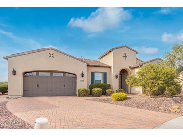 Charming stucco home featuring a brick driveway, two-car garage, and well-maintained landscaping at 30056 N 129Th Ave, Peoria, AZ 85383