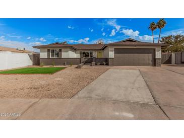 Charming single-story home with a tidy front yard, wide driveway, and two-car garage at 709 N San Jose N Cir, Mesa, AZ 85201