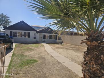 Charming single-story home featuring desert landscaping and a walkway leading to the front door at 713 E Amelia Ave, Phoenix, AZ 85014