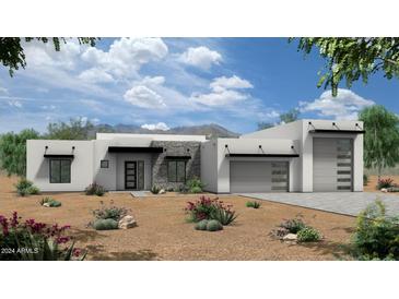 Modern home featuring a stone facade, desert landscaping, and a three-car garage at 7195 E Rancho Del Oro Dr, Scottsdale, AZ 85266