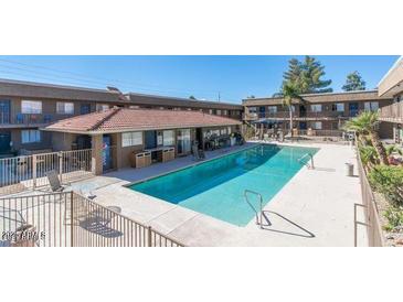 Inviting swimming pool surrounded by well-maintained condos, perfect for relaxation at 18202 N Cave Creek Rd # 106, Phoenix, AZ 85032