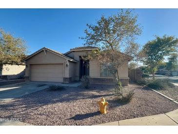 Charming single-story home showcasing desert landscaping, a two-car garage, and light tan stucco at 4943 W Lynne Ln, Laveen, AZ 85339
