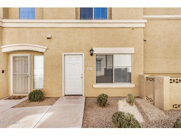 Tan home exterior featuring a well-maintained front yard with desert landscaping at 525 N Miller Rd # 113, Scottsdale, AZ 85257