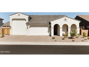 Charming single-Gathering home featuring a three-car garage, covered porch, and beautifully landscaped front yard at 17816 W Oregon Ave, Litchfield Park, AZ 85340