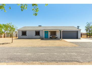 Charming single-story home with a gravel front yard, blue door, and attached garage at 28213 N Holly Rd, San Tan Valley, AZ 85143