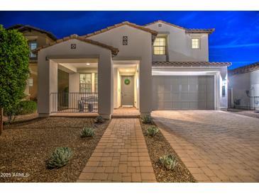 Charming two-story home with a well-manicured front yard and a welcoming entrance at night at 3841 E Oxford Ln, Gilbert, AZ 85295