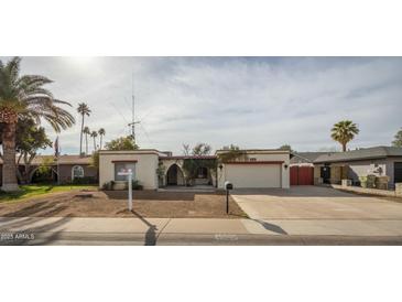 Traditional single-story home with a two-car garage, mature landscaping, and a neutral-toned exterior at 4925 W Mercer Ln, Glendale, AZ 85304