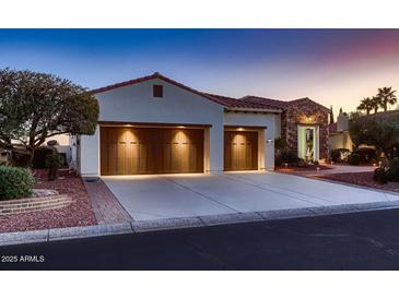 Beautiful single-story home featuring a three-car garage, stone accents, and lovely desert landscaping at 13117 W Micheltorena Dr, Sun City West, AZ 85375