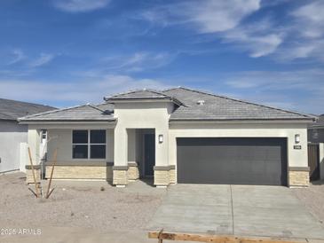 Charming single-story home with a gray roof, neutral stucco exterior, and a two-car garage at 15406 W Hackamore Dr, Surprise, AZ 85387