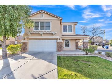 Inviting two-story home featuring stone accents, a well-manicured lawn, and a spacious two-car garage at 16029 N 171St Dr, Surprise, AZ 85388