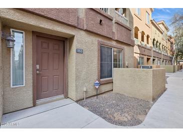 Exterior of a two-story townhome featuring a private front entrance and manicured landscaping at 1920 E Bell Rd # 1153, Phoenix, AZ 85022