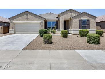 Charming single-story home featuring a neutral color scheme, well-manicured landscaping and a two-car garage at 26020 N 138Th Ln, Peoria, AZ 85383