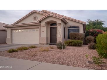 Charming single-story home featuring a two-car garage, desert landscaping, and a cozy front porch entrance at 4032 E Jojoba Rd, Phoenix, AZ 85044