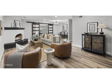 Charming living room features a cozy fireplace, modern furniture, and an open layout leading to the kitchen at 6207 N 10Th Way, Phoenix, AZ 85014