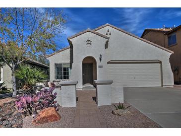 Charming single-story home with a well-manicured desert landscape and an inviting brick walkway at 6614 W Victory N Way, Florence, AZ 85132