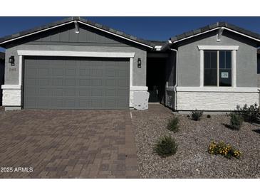 Charming single-story home featuring a gray color scheme, paver driveway, and low-maintenance desert landscaping at 21465 N Rummler Ln, Maricopa, AZ 85138