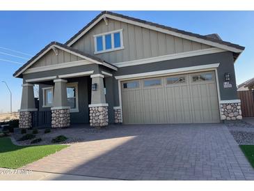 Charming single-Gathering home featuring a two-car garage and a beautifully landscaped front yard and stone accents at 23161 E Mockingbird Dr, Queen Creek, AZ 85142