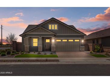 Charming single-story home with well-maintained landscaping, stone accents, and a paved driveway at 23161 E Mockingbird Dr, Queen Creek, AZ 85142