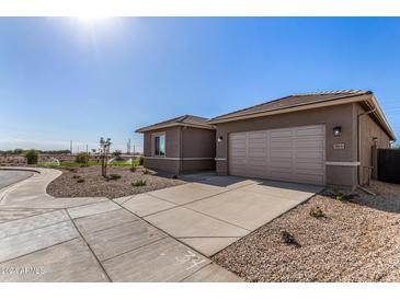 New construction home featuring a concrete driveway, two-car garage, and low maintenance desert landscaping at 31476 N Hayweather Ln, San Tan Valley, AZ 85143
