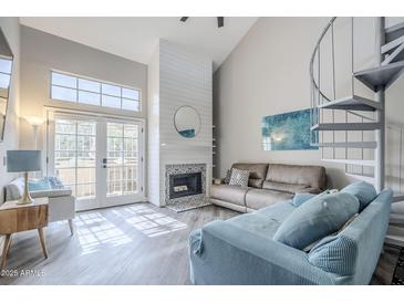Inviting living room with a fireplace, spiral staircase, and bright natural light at 7675 E Mcdonald Dr # 222, Scottsdale, AZ 85250