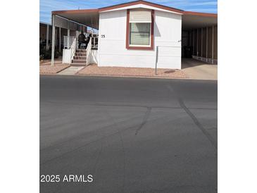 Charming single-story home featuring white siding and well-maintained front yard with carport at 11596 W Sierra Dawn Blvd # 75, Surprise, AZ 85378