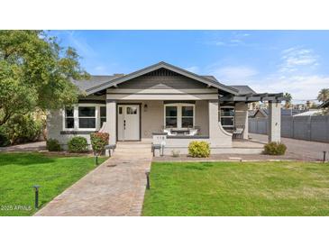 Charming home featuring manicured lawn, inviting porch, and brick walkway at 118 W Palm Ln, Phoenix, AZ 85003