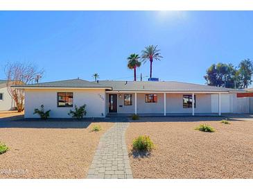 Charming single-story home featuring desert landscaping, a brick walkway, and a welcoming front porch at 1215 E Cambridge Ave, Phoenix, AZ 85006