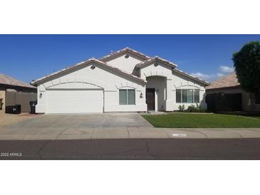 Charming single-story home featuring a well-manicured lawn, attached two car garage, and neutral colored stucco facade at 15971 N 91St Dr, Peoria, AZ 85382