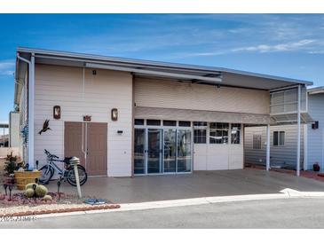 Exterior of home with tandem carport, additional storage and mature landscaping at 17200 W Bell Rd # 845, Surprise, AZ 85374