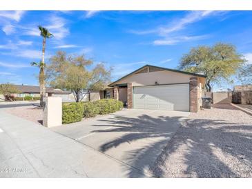 Charming single-story home with a desert landscape, palm tree, and a two-car garage at 19061 N 5Th Ave, Phoenix, AZ 85027