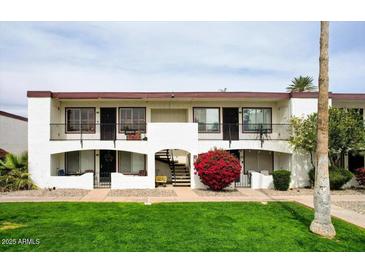 Charming two-story condo with landscaped yard and beautiful red bougainvillea at 240 S Old Litchfield Rd # 206, Litchfield Park, AZ 85340