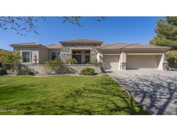 Charming stucco home featuring a well-manicured lawn and a spacious three car garage at 56 S Prairie Rd, Gilbert, AZ 85296