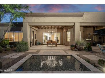 Spacious covered patio featuring an outdoor dining area and serene water feature at 6993 E Soaring Eagle Way, Scottsdale, AZ 85266