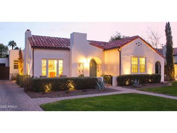 Charming home featuring a red tile roof, stucco walls, manicured landscaping, and pathway leading to an arched front door at 1307 W Palm Ln, Phoenix, AZ 85007