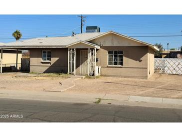 Traditional home featuring a brick exterior, simple landscaping, and a covered entryway at 2201 N 35Th Dr, Phoenix, AZ 85009