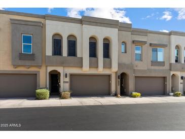 Modern townhome showcasing a neutral color scheme, attached garages, and well-maintained landscaping at 23065 N 75Th St, Scottsdale, AZ 85255