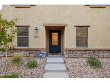 Charming front entrance featuring a black door, stone accents, and manicured landscaping at 3911 S 79Th Ln, Phoenix, AZ 85043