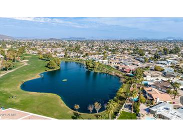 Beautiful aerial view of lake with lush green spaces near homes in a suburban neighborhood at 4606 W Continental Dr, Glendale, AZ 85308