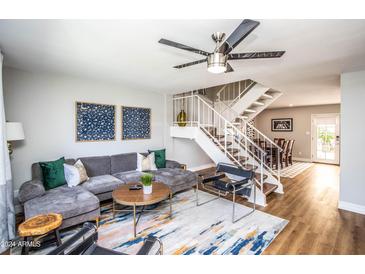 Stylish living room features a plush gray sofa, modern decor, and a staircase leading to the upper level at 5094 N 83Rd St, Scottsdale, AZ 85250