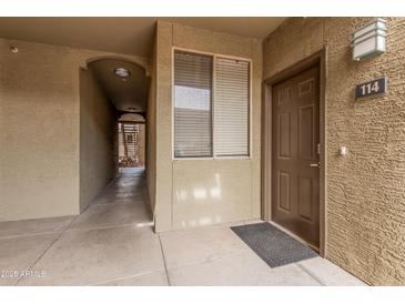 View of the exterior entrance to unit 114 with a textured wall and walkway at 5303 N 7Th St # 114, Phoenix, AZ 85014