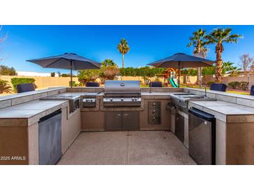 Entertain with ease in this backyard featuring a complete outdoor kitchen and stainless steel appliances at 5331 N Pajaro Ct, Litchfield Park, AZ 85340