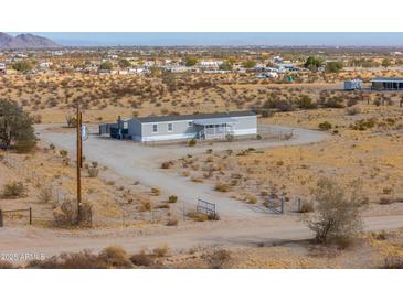 Exterior of single-story home featuring a fenced yard and desert landscaping at 53974 W Barrel Rd, Maricopa, AZ 85139