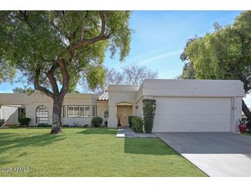 Charming single story home with well-manicured lawn, mature trees, and a two-car garage at 6315 E Kelton Ln, Scottsdale, AZ 85254