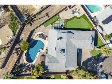 Stunning aerial view of backyard oasis featuring pool, putting green, and lush landscaping at 6420 N 85Th Pl, Scottsdale, AZ 85250