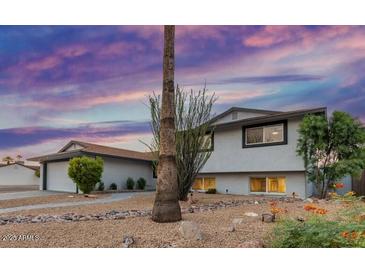Charming home with drought-resistant landscaping, a new roof, and a tranquil atmosphere at sunset at 8602 E Mitchell Dr, Scottsdale, AZ 85251