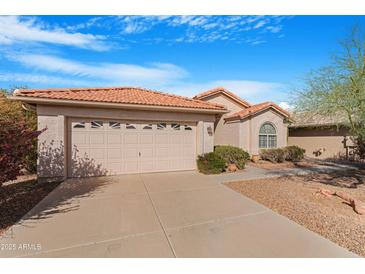 Charming single-story home featuring a two-car garage, landscaped front yard, and a beautiful red tile roof at 9214 E Diamond Dr, Sun Lakes, AZ 85248