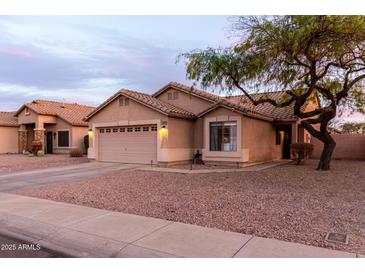 Charming single-story home featuring a two-car garage, neutral stucco, and low-maintenance desert landscaping at 11843 W Cambridge Ave, Avondale, AZ 85392